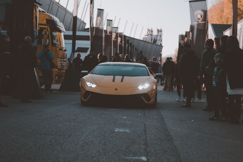 Horsepower - a white sports car parked in front of a crowd of people