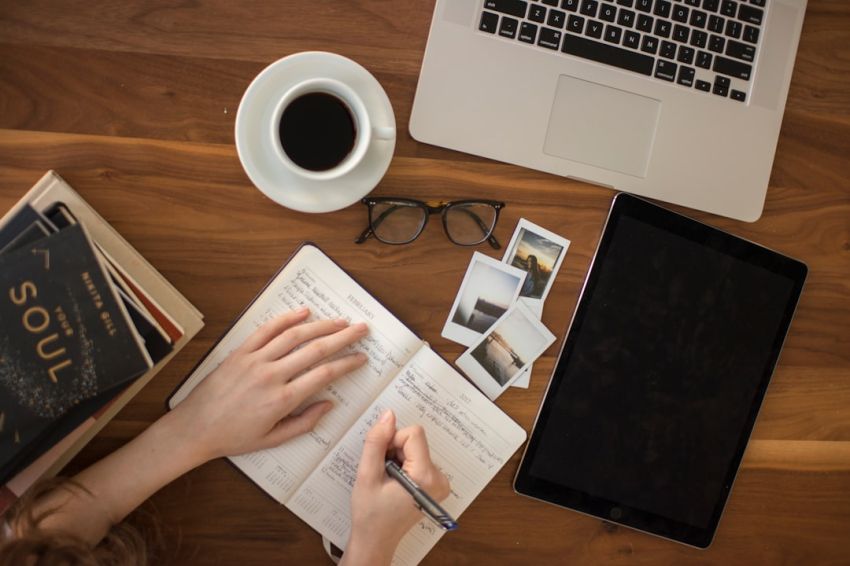 Tips - person holding ballpoint pen writing on notebook