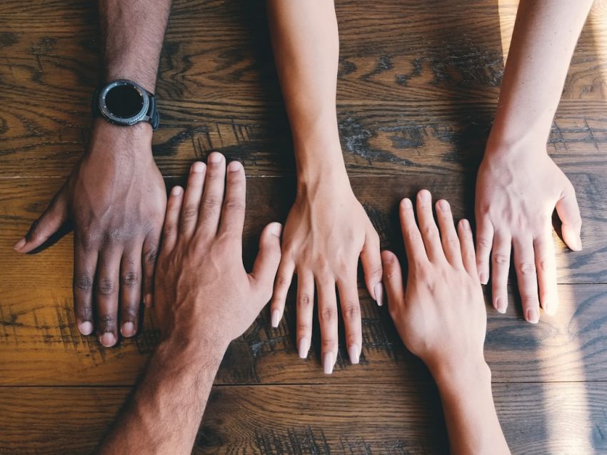 Differences - five human hands on brown surface