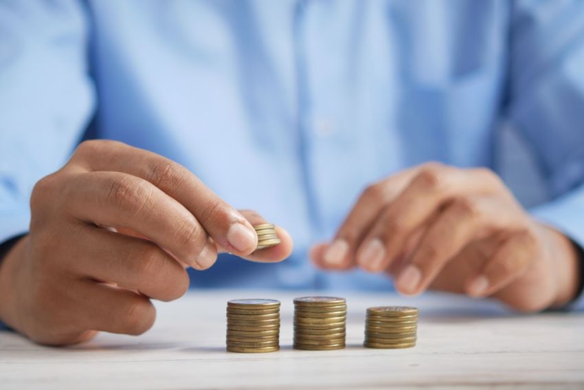 Loan - a person stacking coins on top of a table