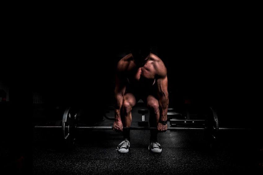 Fitness Goals - topless man in black shorts sitting on black and silver barbell