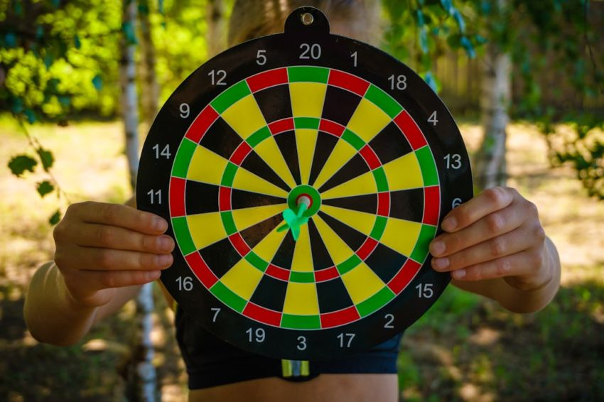 Accuracy - person holding black red yellow and green round analog clock