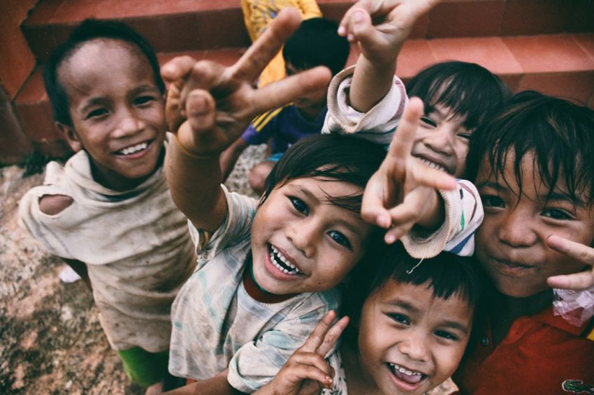 Children - five children smiling while doing peace hand sign