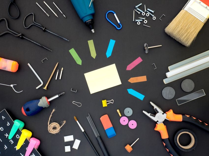 Tools - assorted color plastic tools on gray wooden table