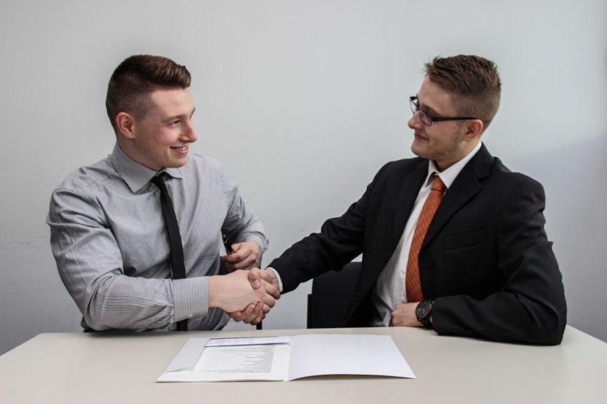 Benefits - two men facing each other while shake hands and smiling